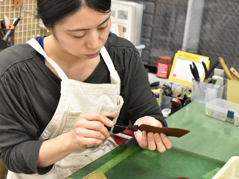 小型の二つ折り財布(WS-64)のコバに染料を塗る様子